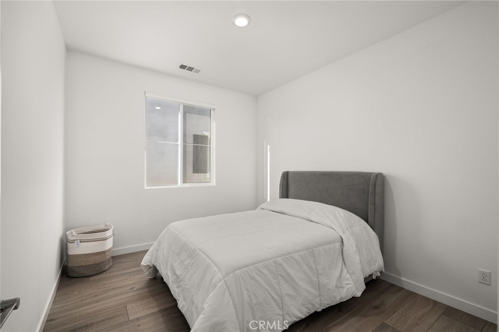 11401 West Serrano Square Yucaipa, CA 92399 - Photo 25 of 46 a bedroom with a bed and wooden floor