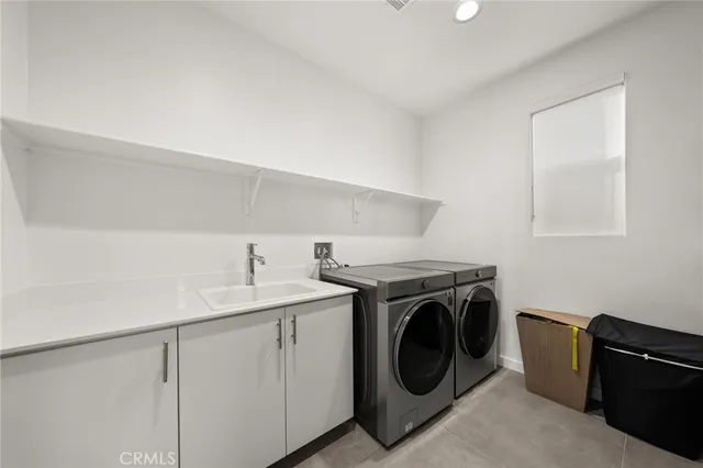a utility room with sink dryer and washer