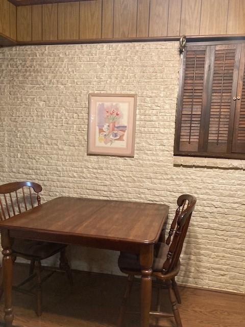 1581 Harbor Road Dallas, TX 75216 - Photo 7 of 15 Brick accent wall with wood-paneled ceiling trim and wood flooring