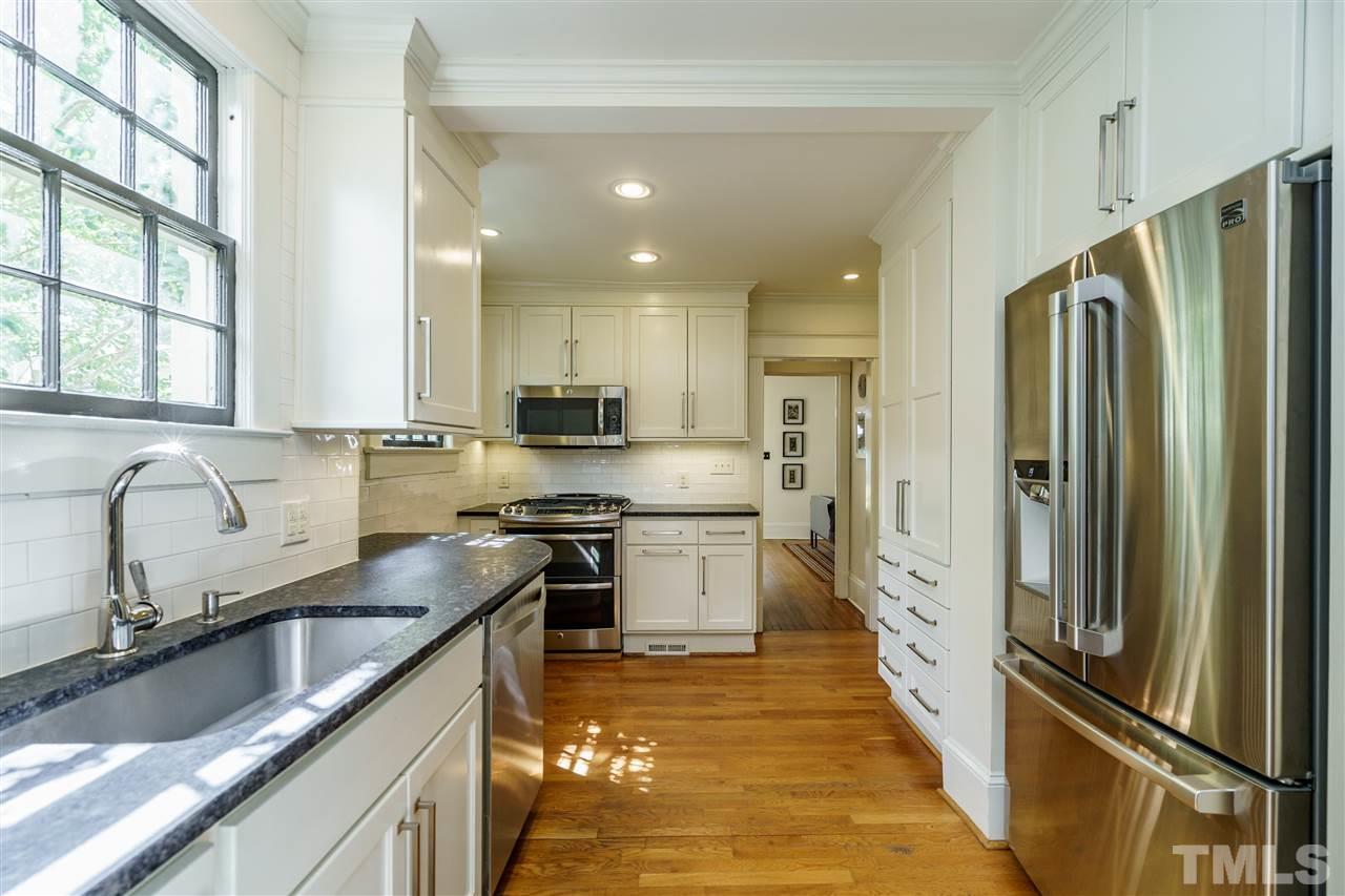 121 Hudson Street Raleigh, NC 27608 - Photo 14 of 30 a kitchen with stainless steel appliances granite countertop a refrigerator a sink dishwasher a stove and white countertops with wooden floor