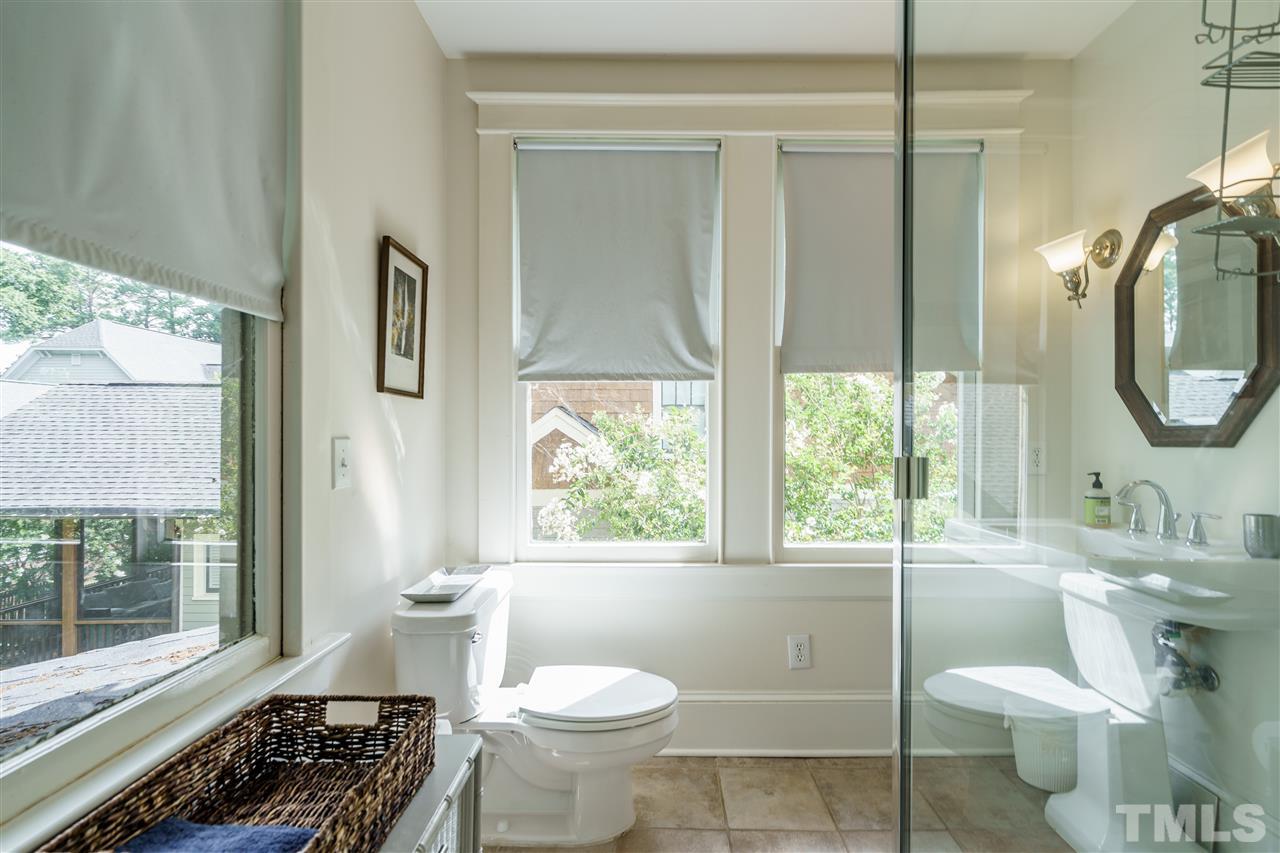 121 Hudson Street Raleigh, NC 27608 - Photo 23 of 30 a bathroom with a toilet sink a mirror and next to a window