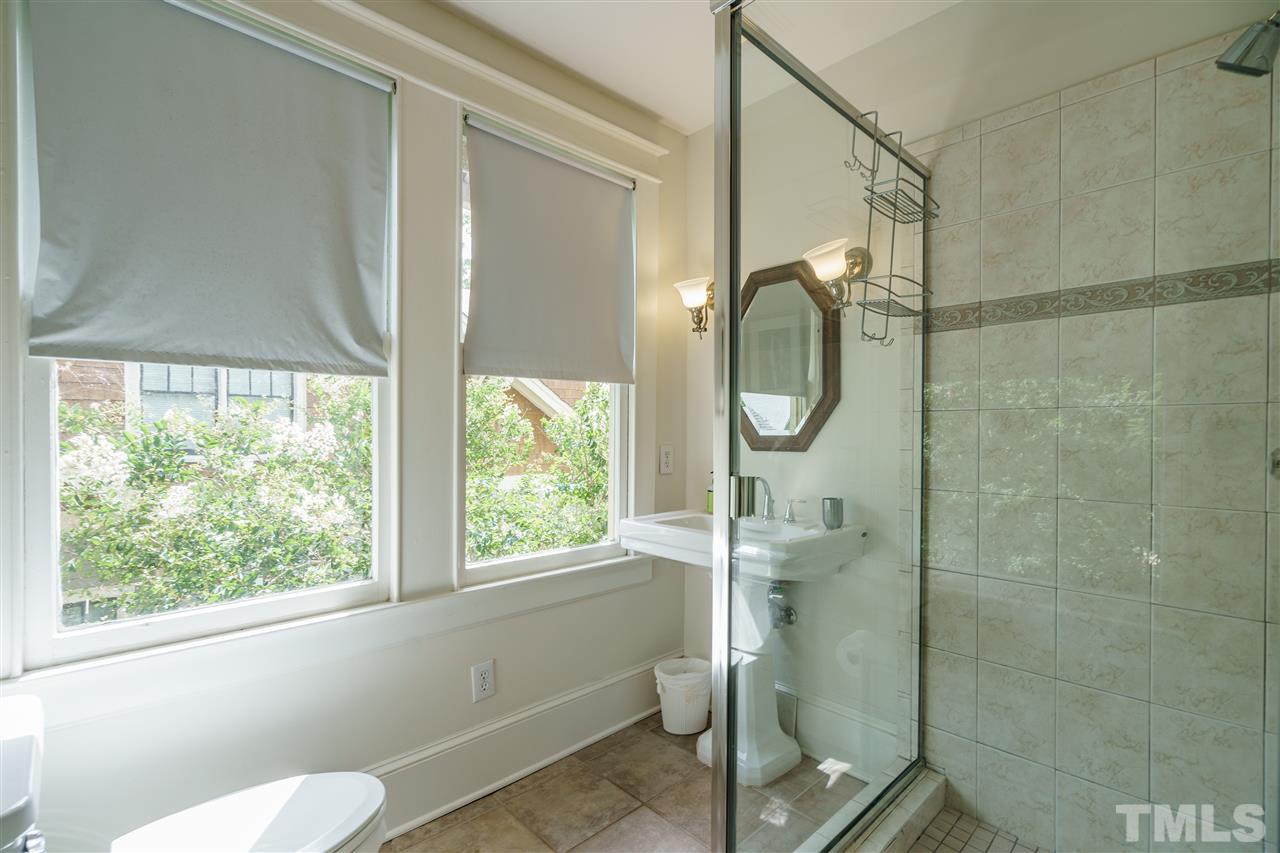 121 Hudson Street Raleigh, NC 27608 - Photo 24 of 30 a bathroom with a granite countertop shower a toilet and a window