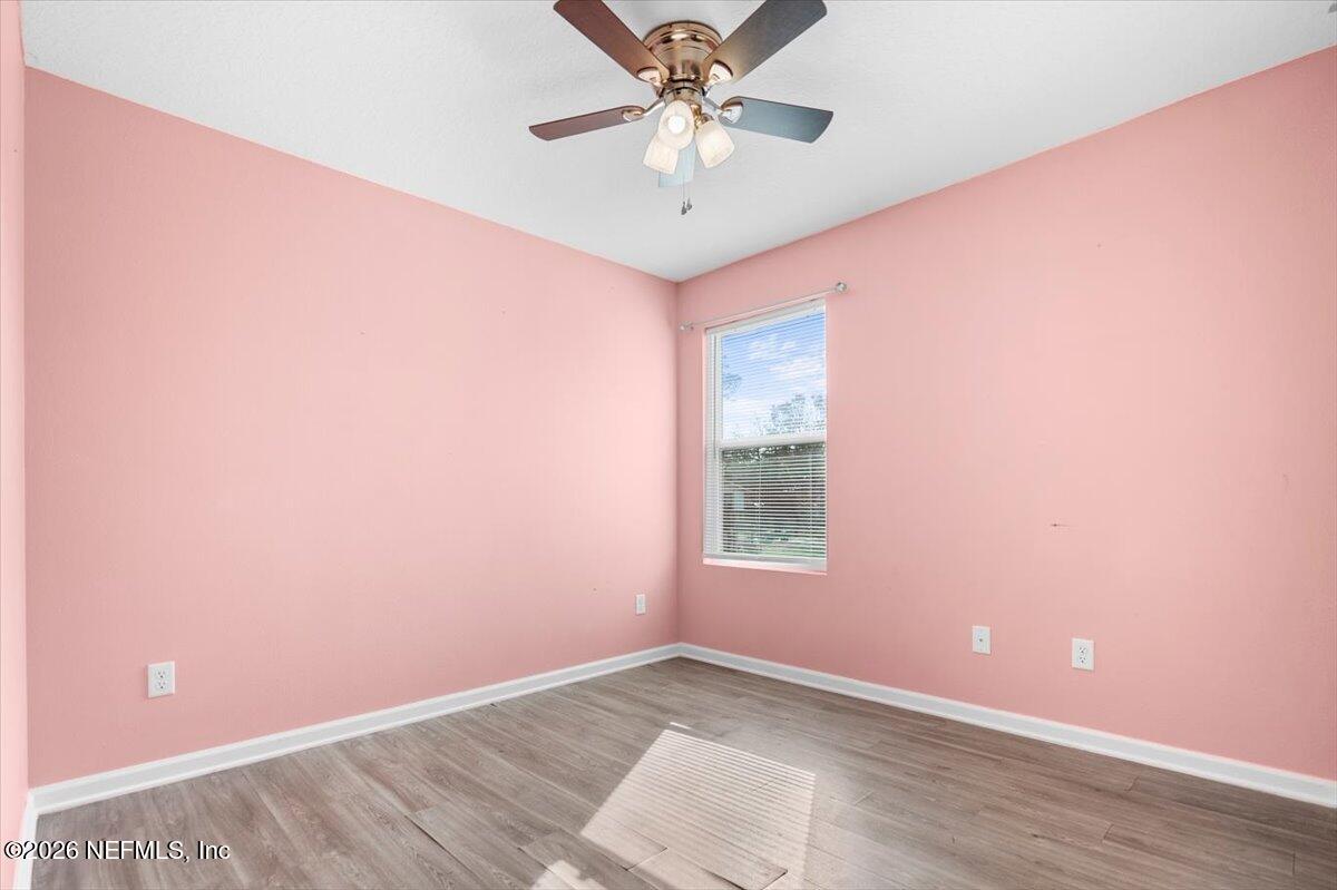 3094 Jennings Road Jacksonville, FL 32218 - Photo 17 of 33 an empty room with a chandelier fan and windows