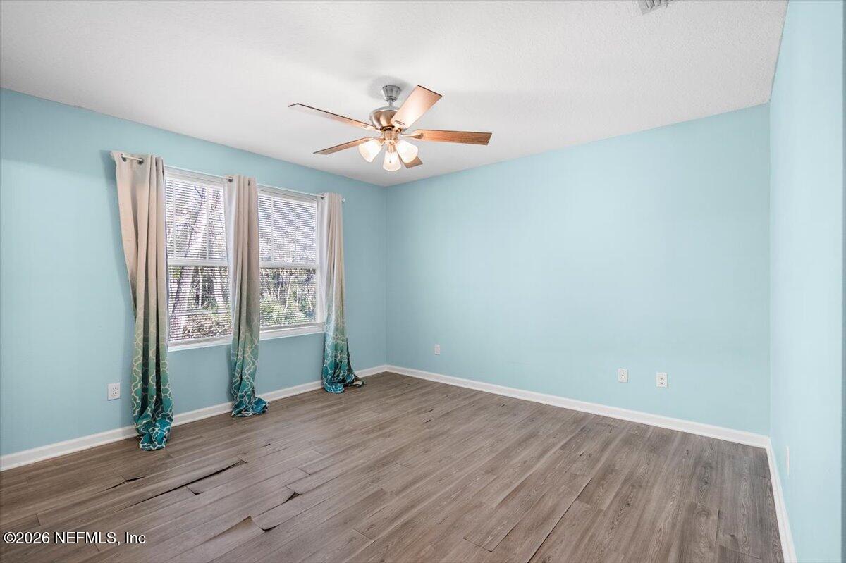 3094 Jennings Road Jacksonville, FL 32218 - Photo 19 of 33 an empty room with wooden floor fan and windows