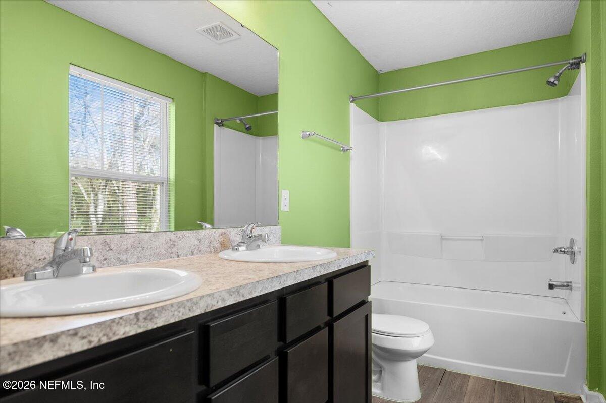 3094 Jennings Road Jacksonville, FL 32218 - Photo 22 of 33 a bathroom with a granite countertop sink toilet and shower