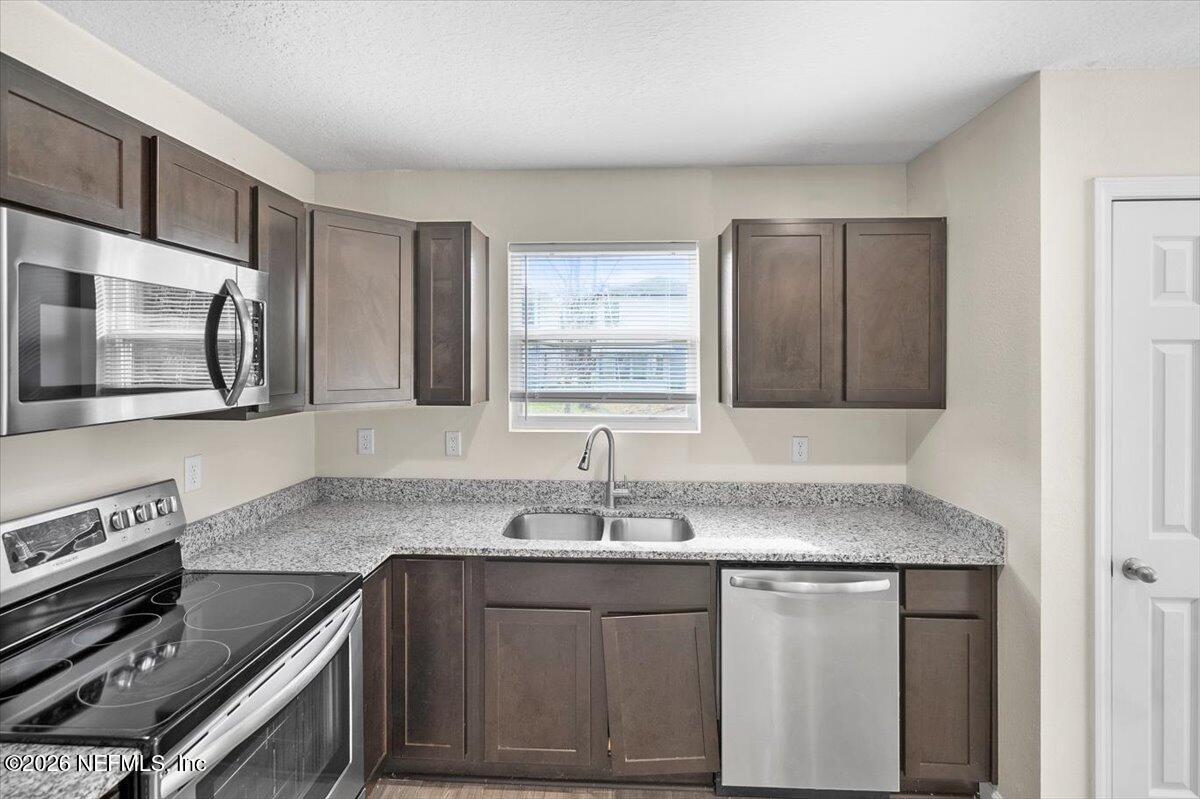 3094 Jennings Road Jacksonville, FL 32218 - Photo 9 of 33 a kitchen with stainless steel appliances granite countertop a sink stove and microwave