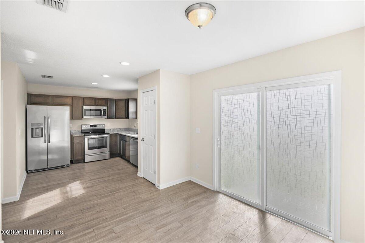 3094 Jennings Road Jacksonville, FL 32218 - Photo 10 of 33 a kitchen with stainless steel appliances granite countertop a refrigerator a sink a stove and oven with wooden floor