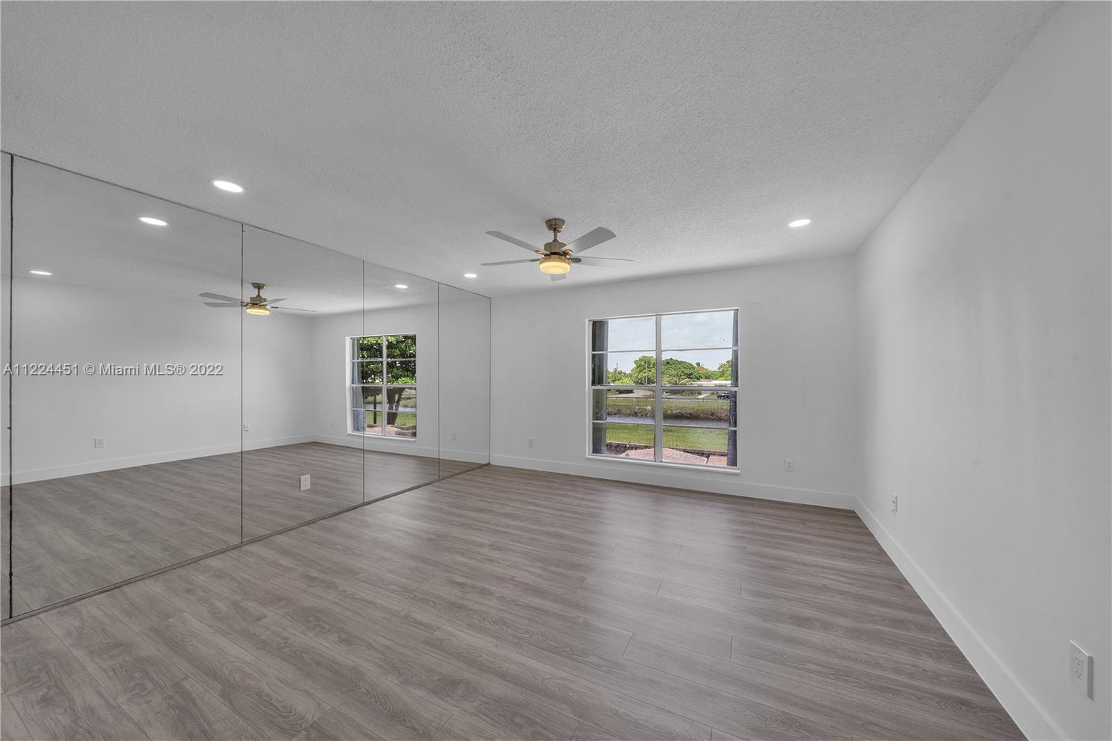 6211 Southwest 116th Place, Unit C22 Miami, FL 33173 - Photo 18 of 32 an empty room with wooden floor and windows