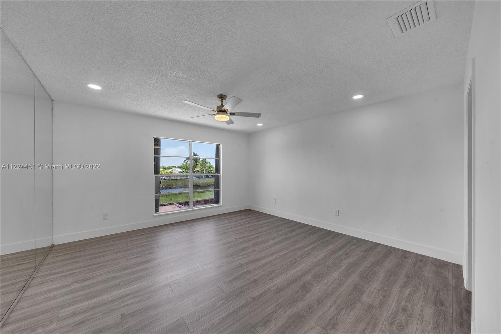 6211 Southwest 116th Place, Unit C22 Miami, FL 33173 - Photo 19 of 32 an empty room with wooden floor and windows