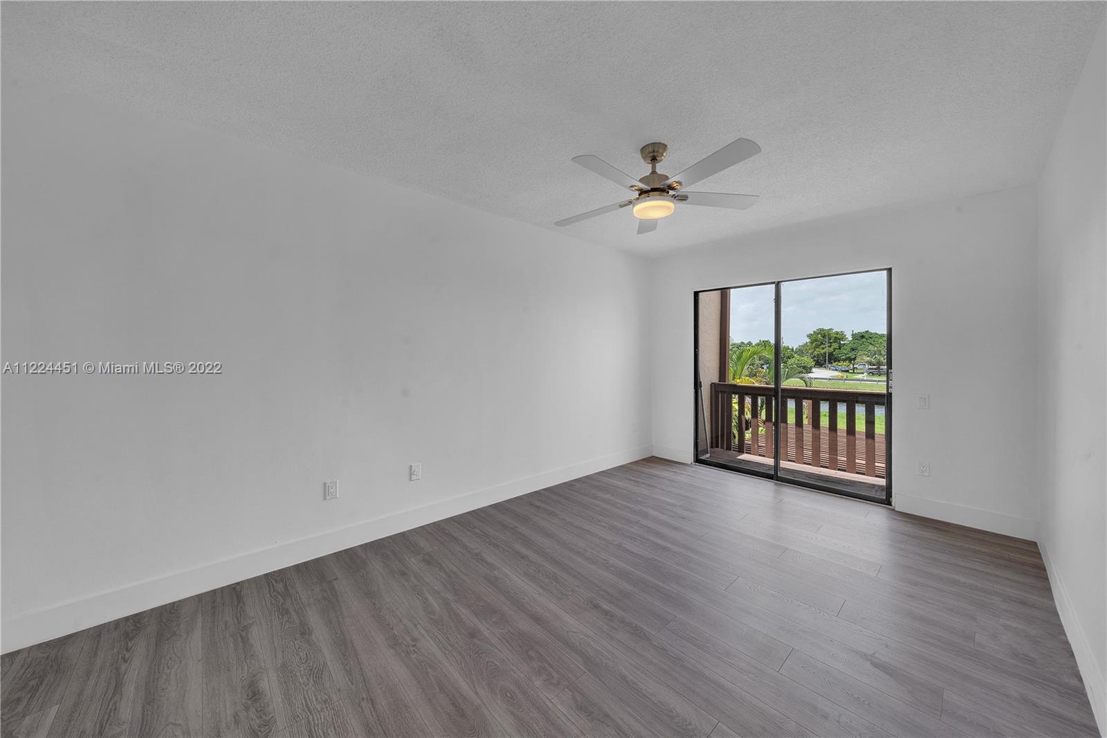 6211 Southwest 116th Place, Unit C22 Miami, FL 33173 - Photo 20 of 32 a view of an empty room with a window and wooden floor