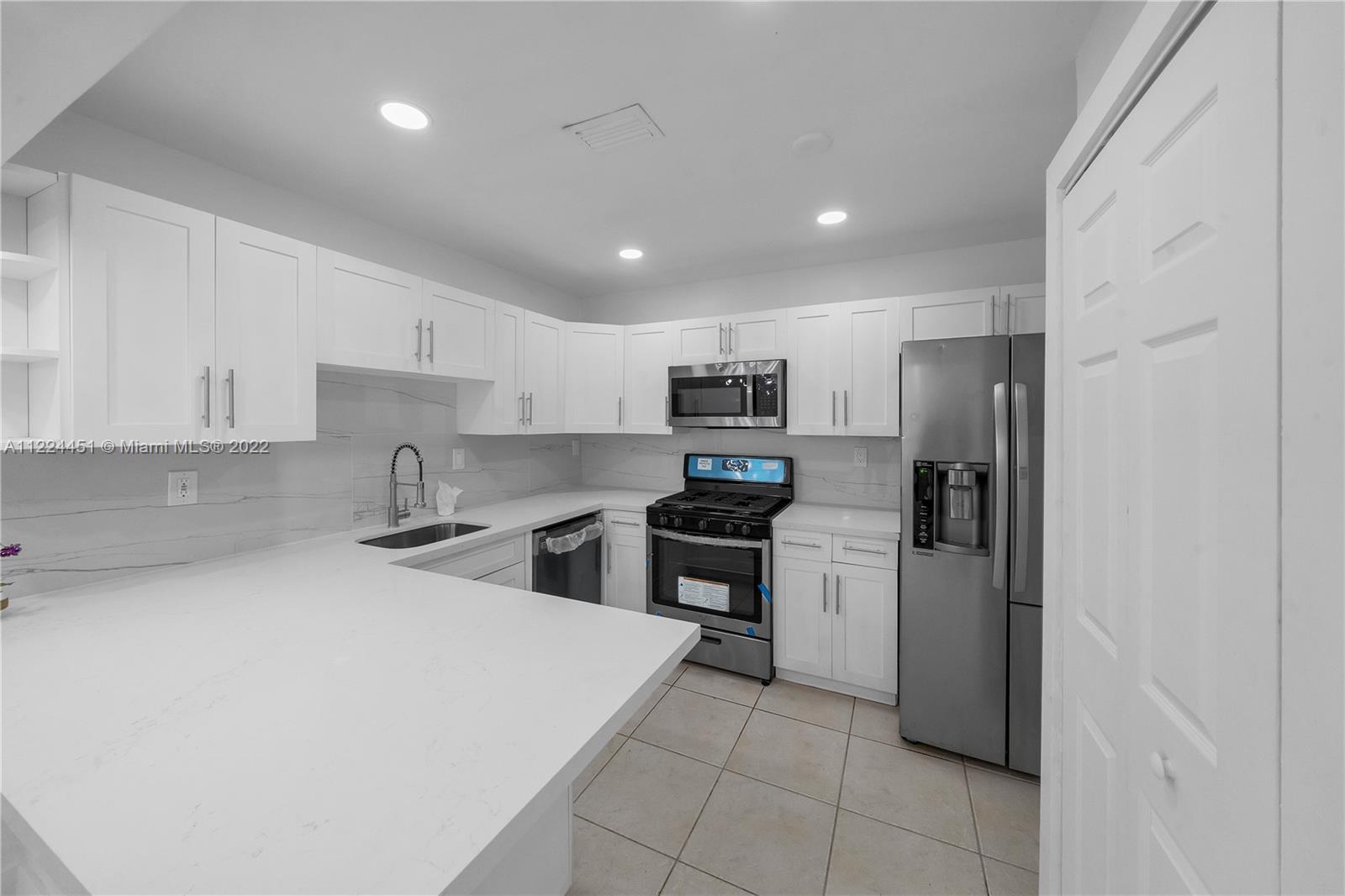 6211 Southwest 116th Place, Unit C22 Miami, FL 33173 - Photo 7 of 32 a kitchen with stainless steel appliances a refrigerator sink and stove