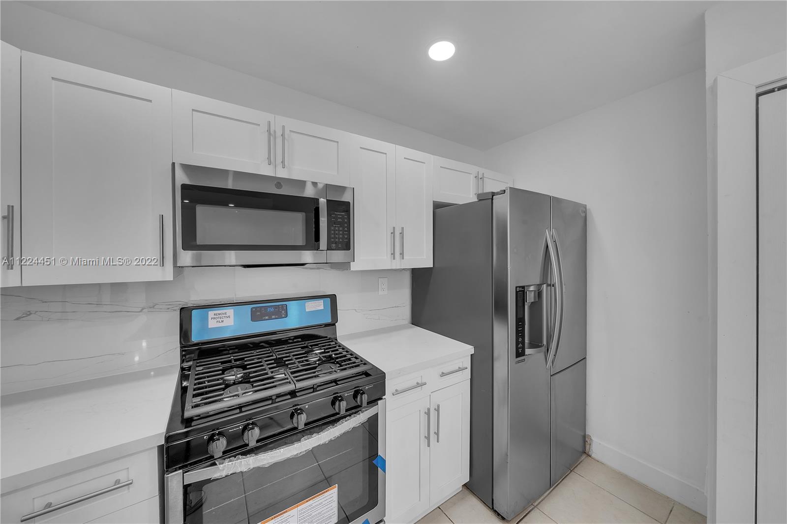 6211 Southwest 116th Place, Unit C22 Miami, FL 33173 - Photo 8 of 32 a kitchen with a stove microwave and refrigerator