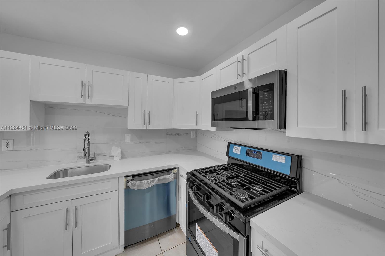 6211 Southwest 116th Place, Unit C22 Miami, FL 33173 - Photo 9 of 32 a kitchen with stainless steel appliances a sink a stove and microwave