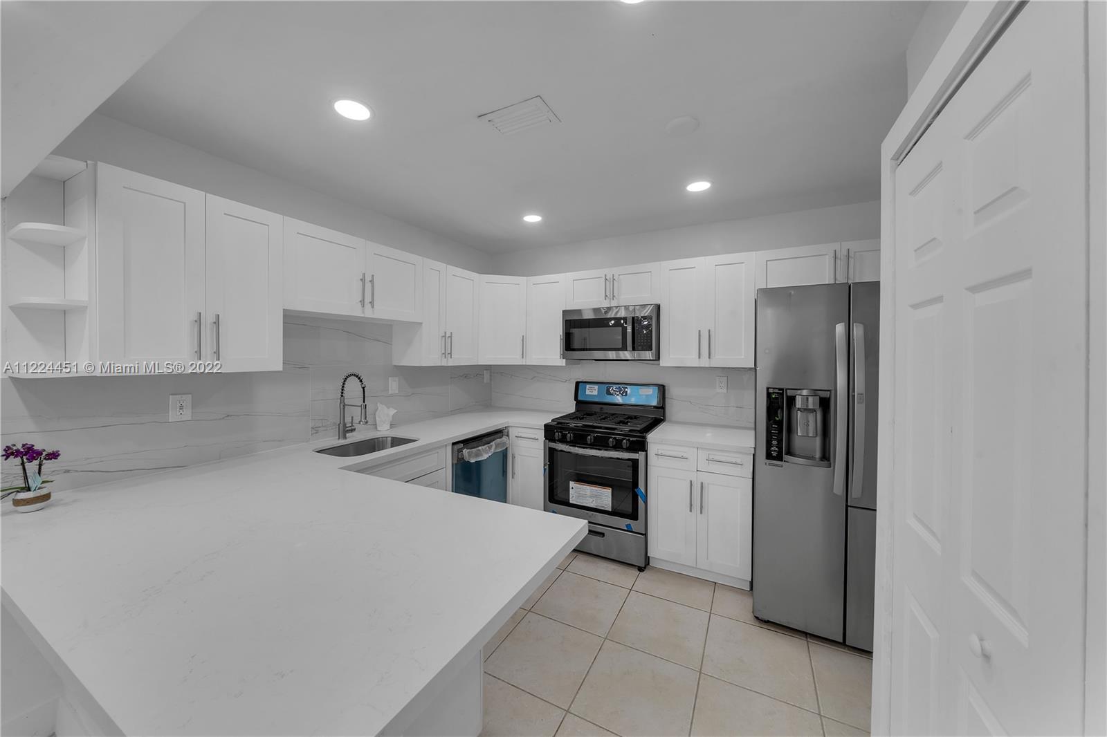 6211 Southwest 116th Place, Unit C22 Miami, FL 33173 - Photo 10 of 32 a kitchen with stainless steel appliances a refrigerator sink and stove