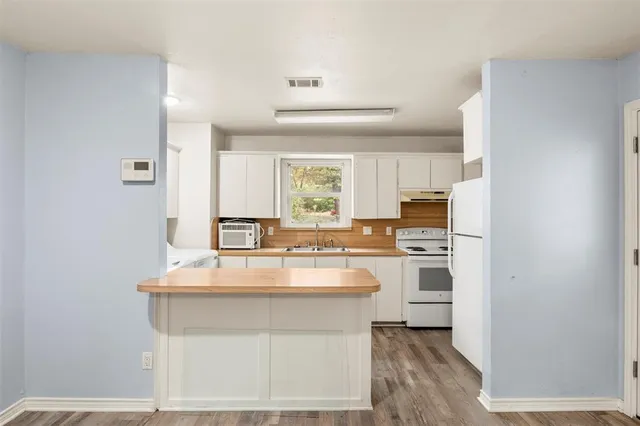 a kitchen with stainless steel appliances a sink a stove a refrigerator and cabinets