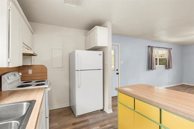 a bedroom with a refrigerator and a stove top oven