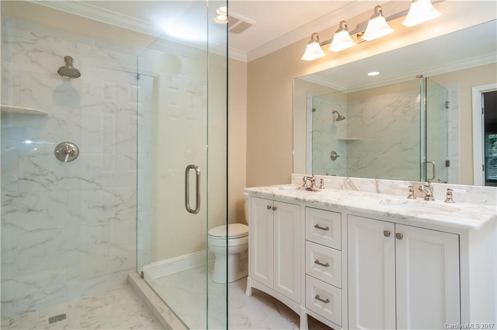 3936 Tilley Morris Road Matthews, NC 28105 - Photo 16 of 24 a bathroom with a granite countertop sink a mirror and shower