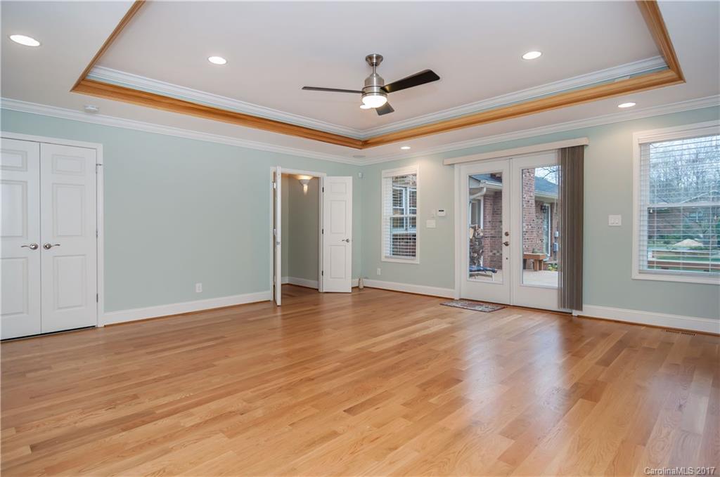 3936 Tilley Morris Road Matthews, NC 28105 - Photo 17 of 24 a view of an empty room with wooden floor and a ceiling fan