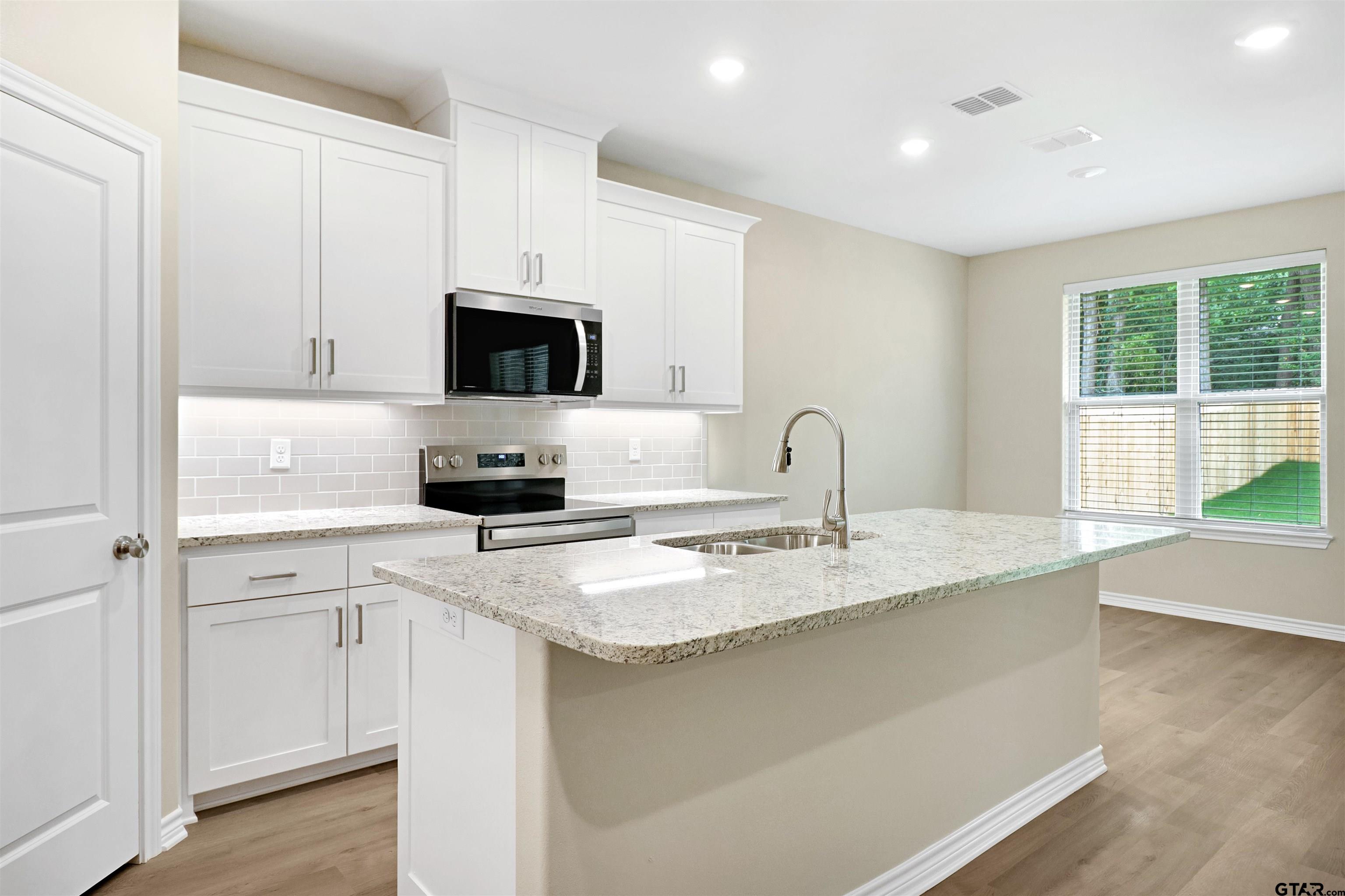 3053 Guinn Farms Road Tyler, TX 75707 - Photo 9 of 32 a kitchen with appliances a sink and a microwave