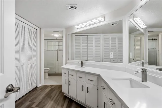 an empty room with wooden floor cabinet and windows