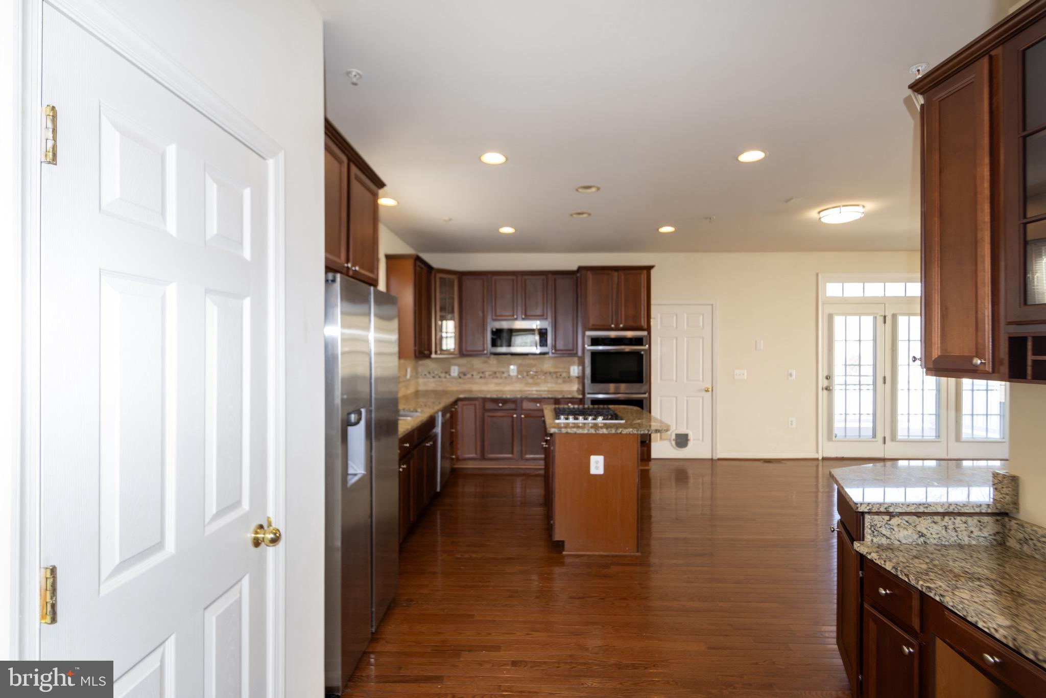9814 Traver Street Bowie, MD 20721 - Photo 12 of 75 a kitchen with stainless steel appliances granite countertop a refrigerator a sink dishwasher and a stove with wooden floor