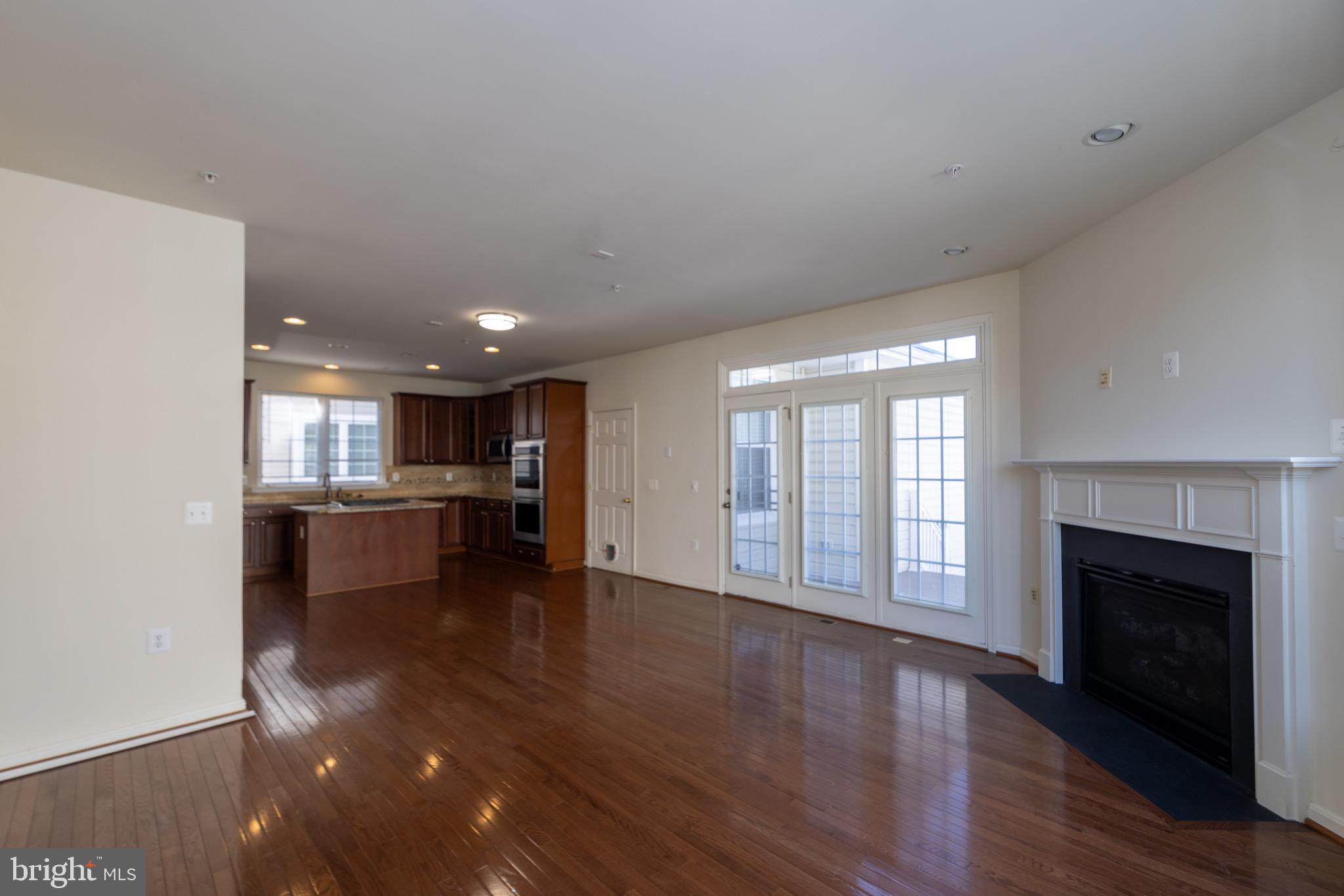9814 Traver Street Bowie, MD 20721 - Photo 15 of 75 a view of empty room with wooden floor and fireplace