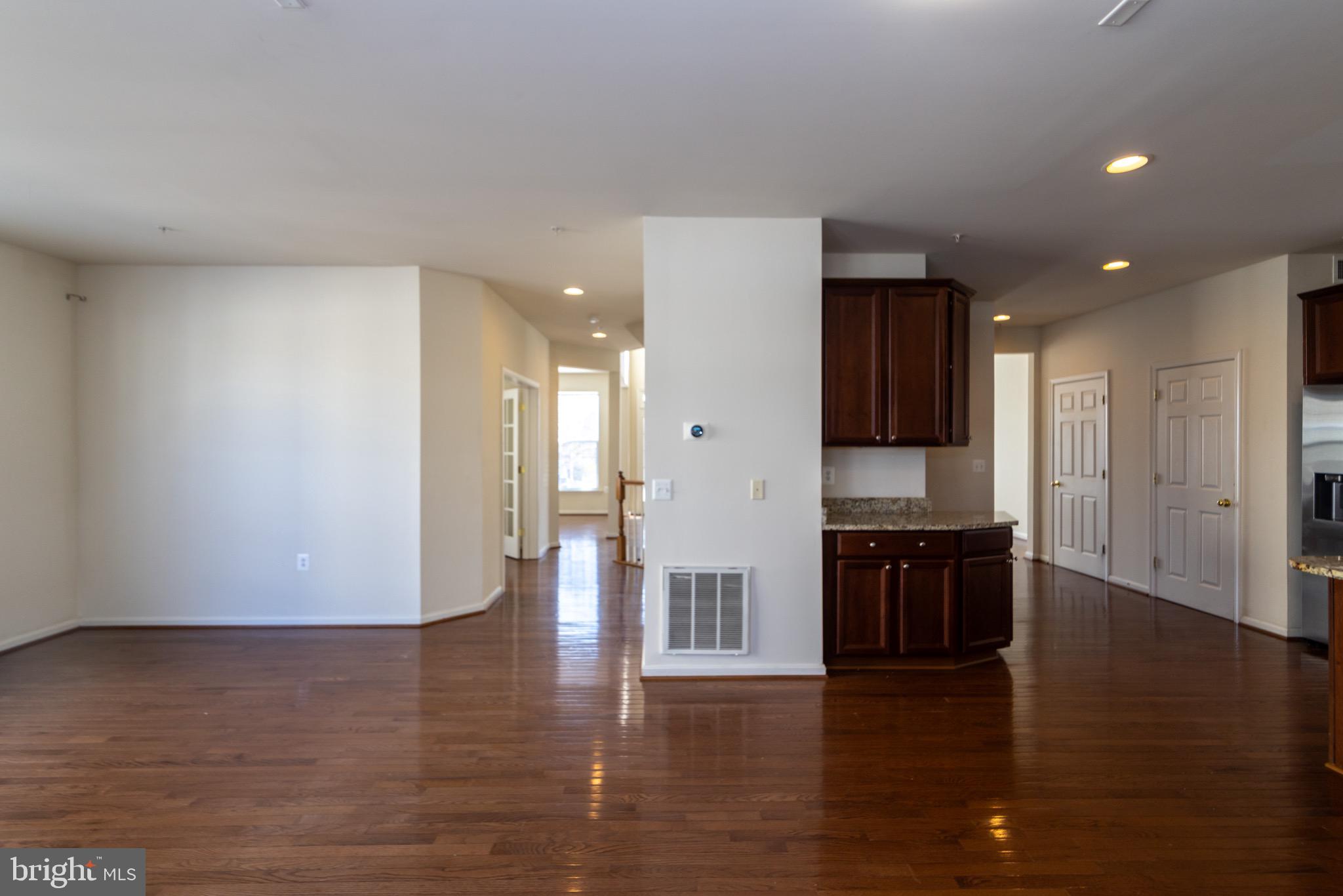9814 Traver Street Bowie, MD 20721 - Photo 18 of 75 a view of an empty room with wooden floor and kitchen