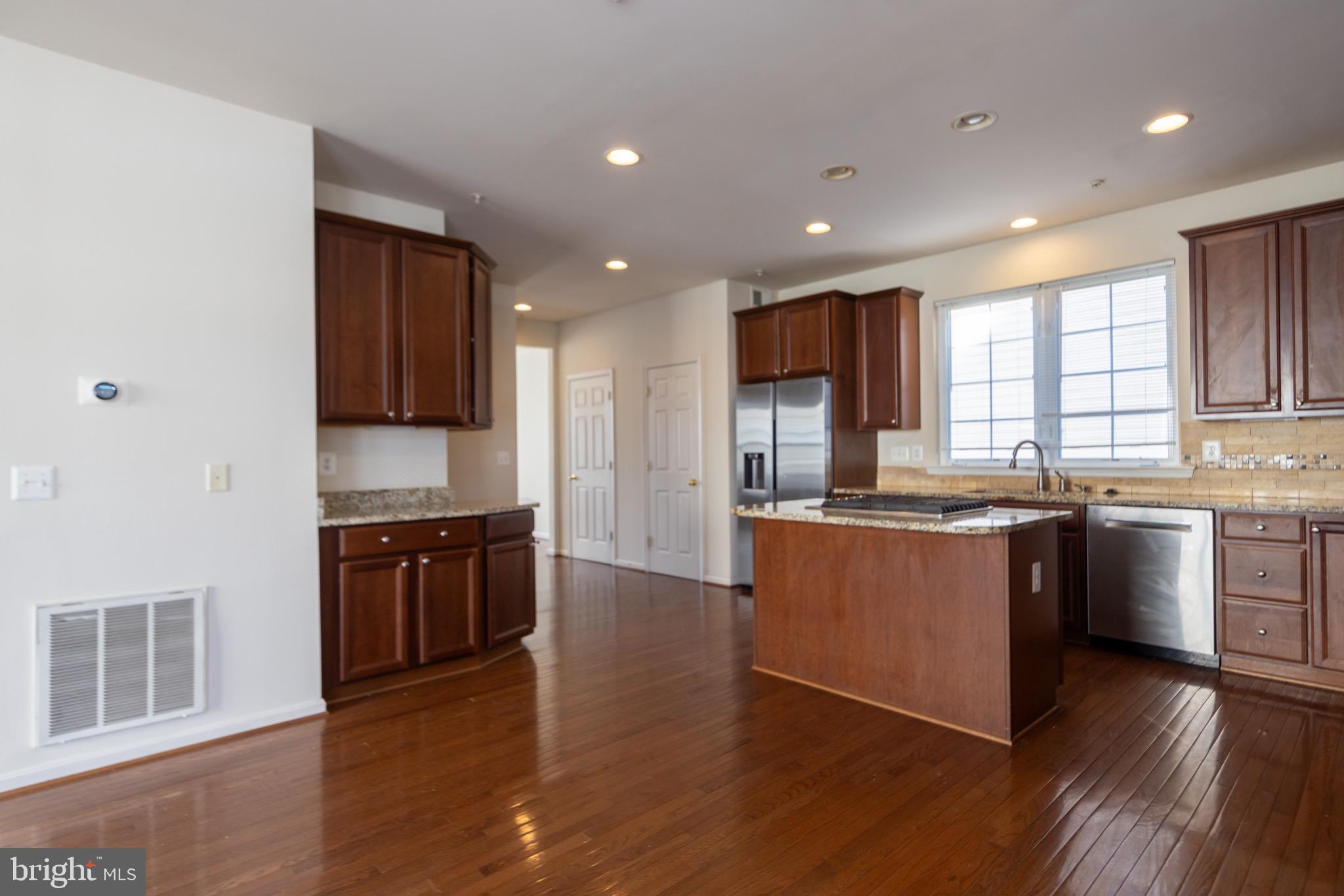 9814 Traver Street Bowie, MD 20721 - Photo 20 of 75 a large kitchen with stainless steel appliances granite countertop a stove a sink a refrigerator and a granite countertops with wooden floor