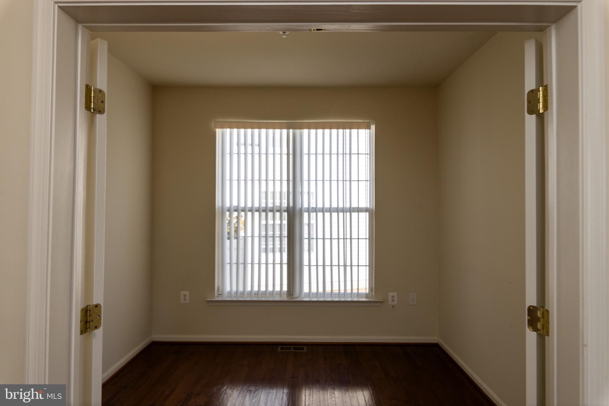 9814 Traver Street Bowie, MD 20721 - Photo 21 of 75 a view of an empty room with wooden floor and a window