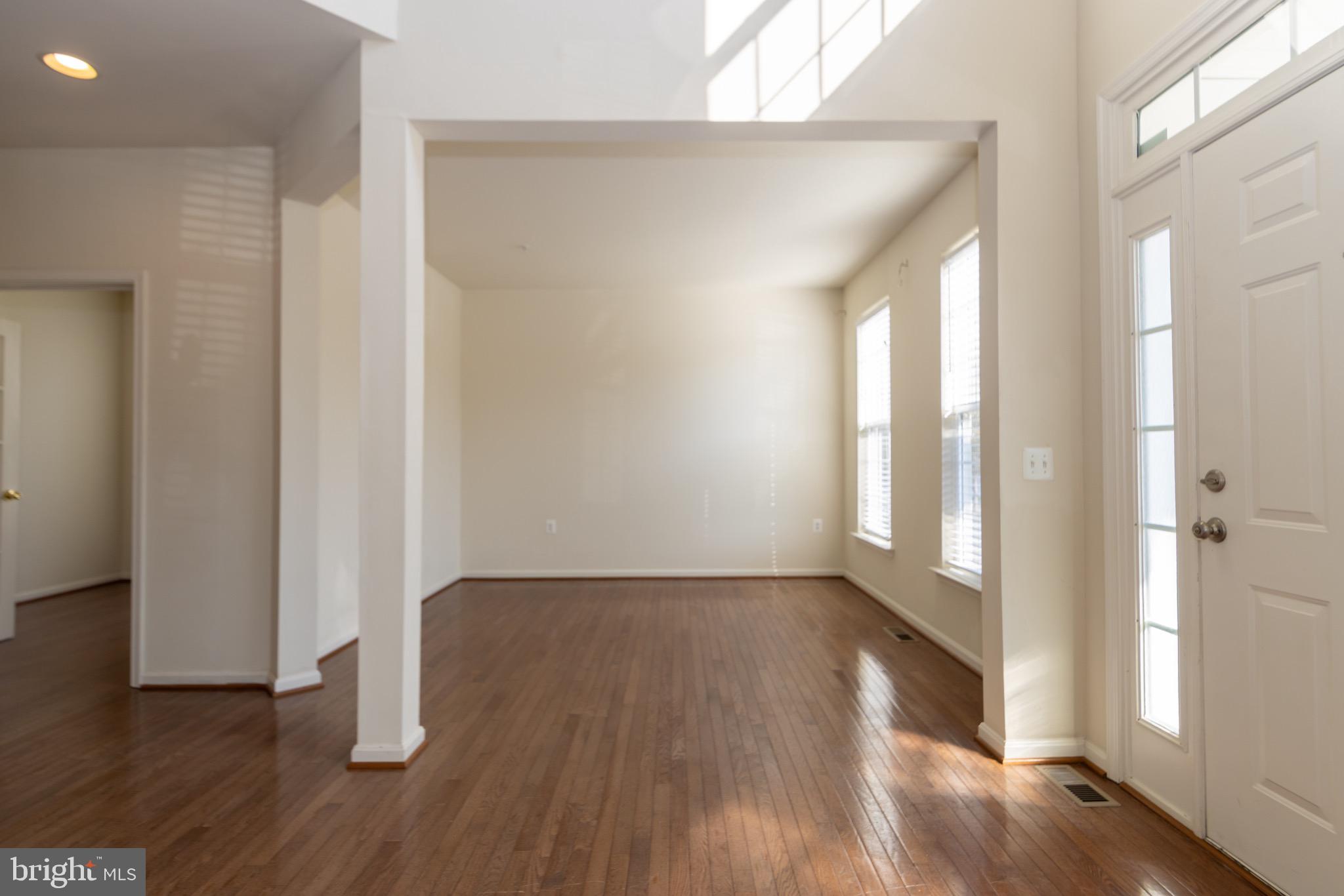 9814 Traver Street Bowie, MD 20721 - Photo 3 of 75 a view of an empty room with wooden floor and a window