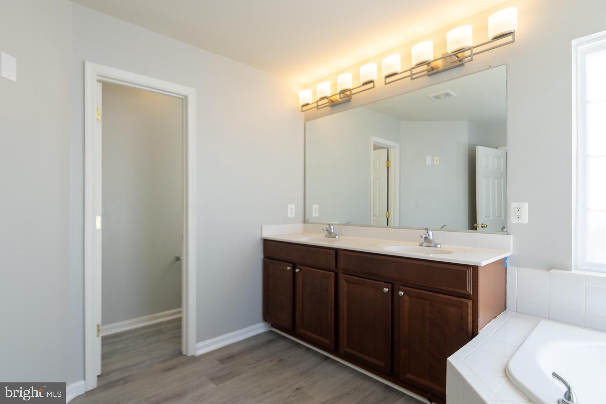 9814 Traver Street Bowie, MD 20721 - Photo 33 of 75 a bathroom with a double vanity sink and mirror with toilet