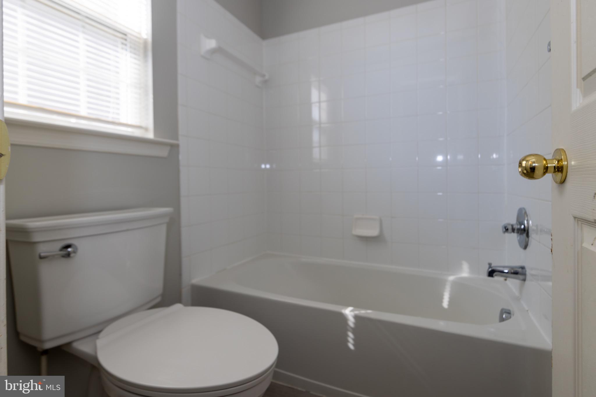 9814 Traver Street Bowie, MD 20721 - Photo 47 of 75 a white toilet and tub sitting next to a window