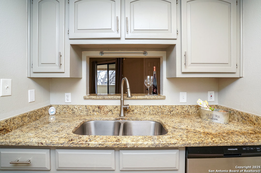 11843 Braesview, Unit 1612 San Antonio, TX 78231 - Photo 12 of 31 a kitchen with granite countertop white cabinets and a sink