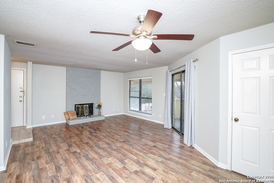 11843 Braesview, Unit 1612 San Antonio, TX 78231 - Photo 2 of 31 a view of a livingroom with a ceiling fan and wooden floor