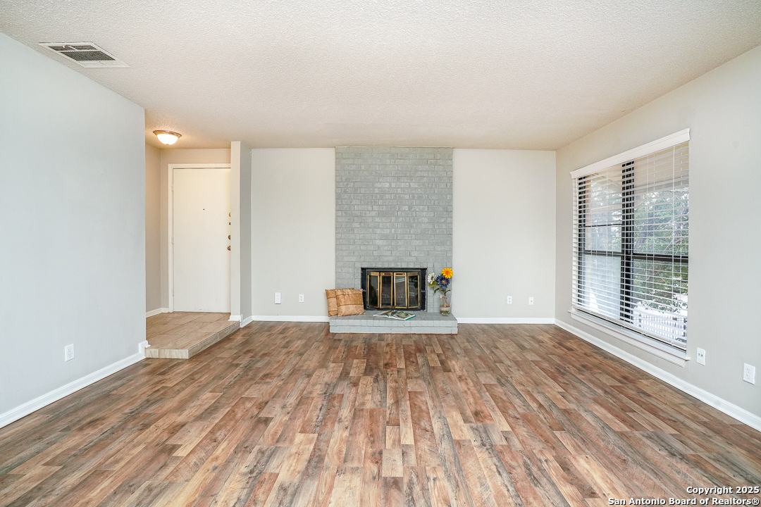 11843 Braesview, Unit 1612 San Antonio, TX 78231 - Photo 7 of 31 a view of an empty room with wooden floor and a window