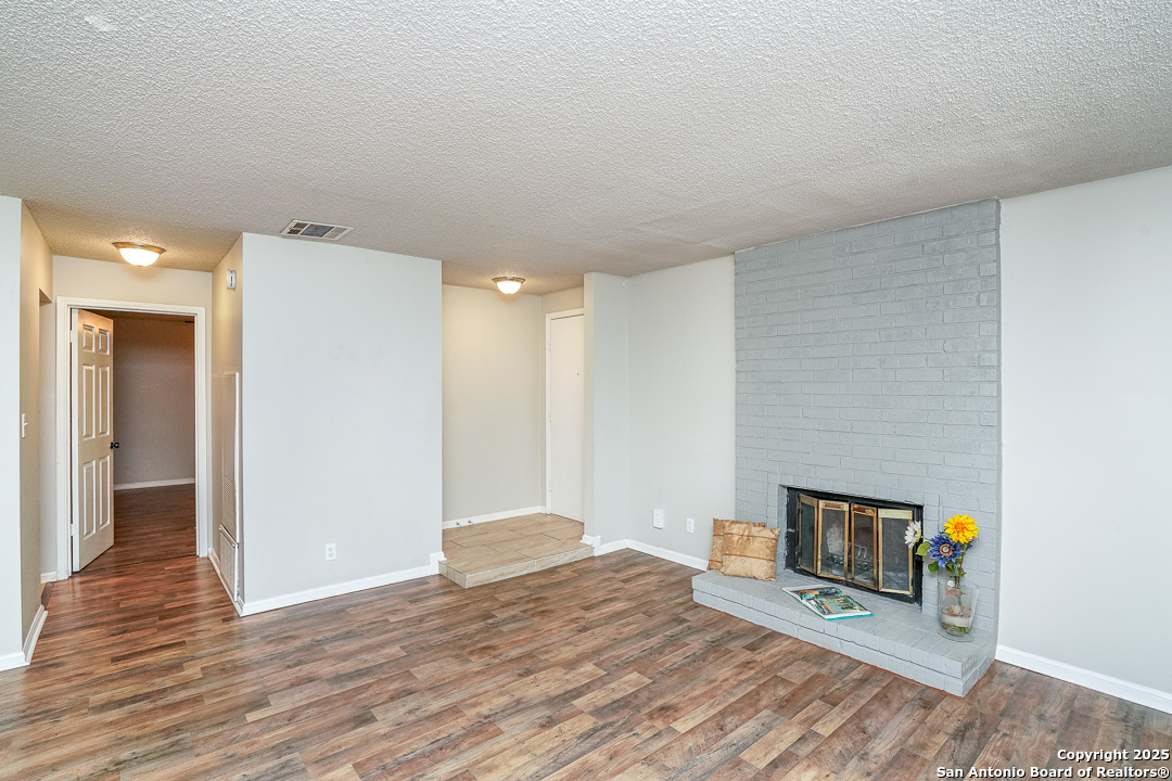 11843 Braesview, Unit 1612 San Antonio, TX 78231 - Photo 8 of 31 a view of a livingroom with wooden floor and a fireplace