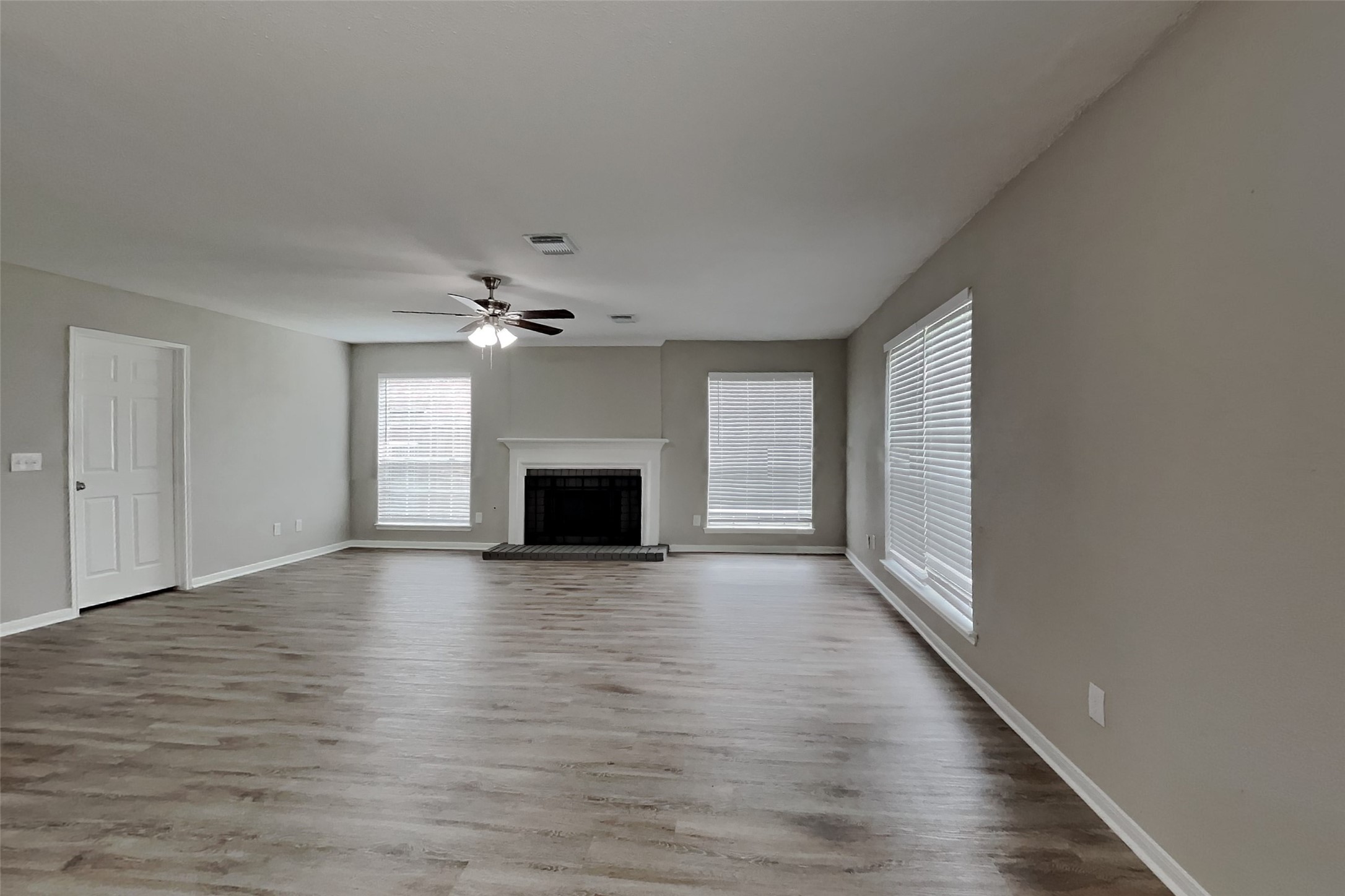 16303 Hickory Point Road Houston, TX 77095 - Photo 3 of 21 an empty room with wooden floor fireplace and windows