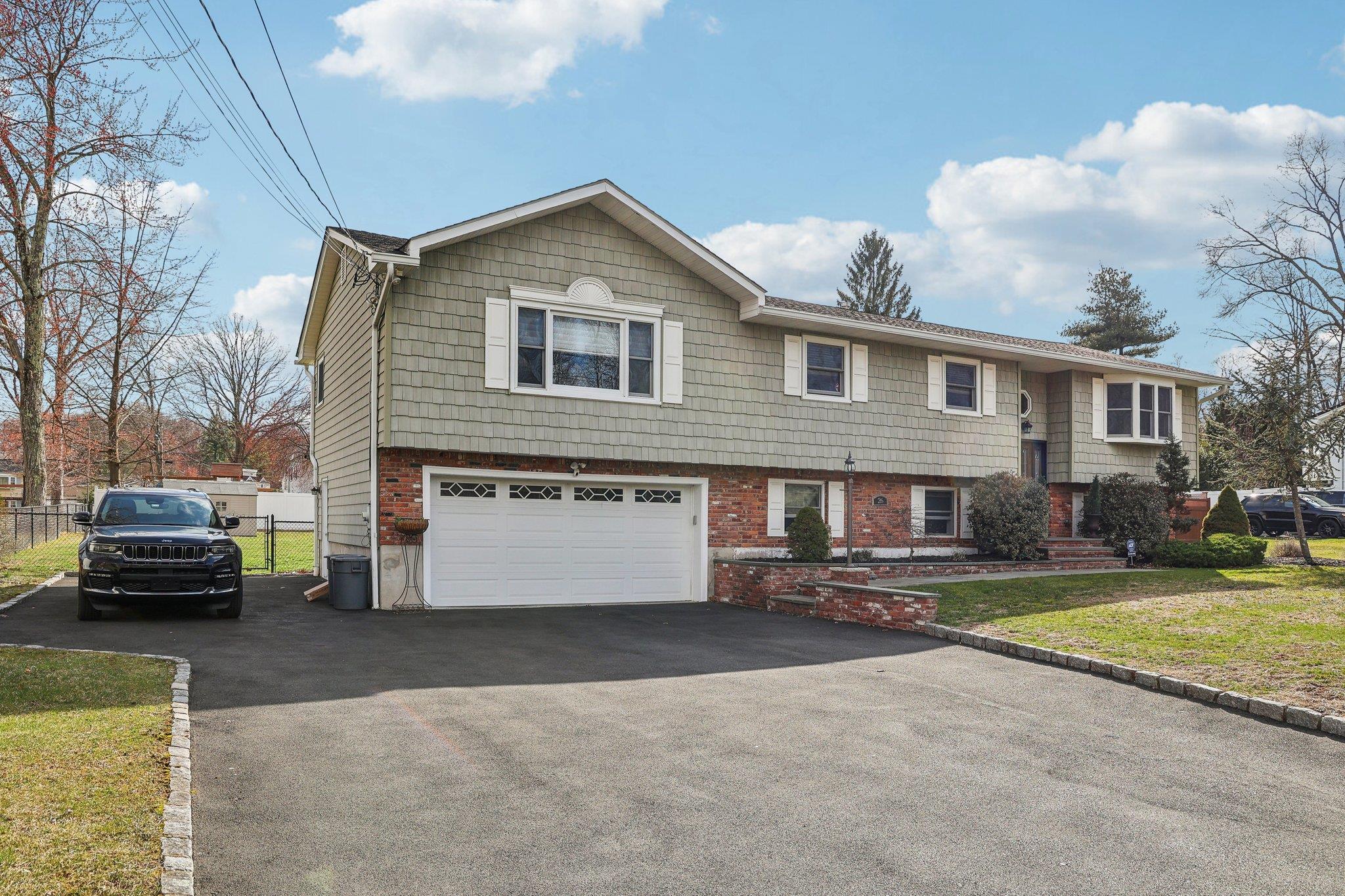26 Dover Road Congers, NY 10920 - Photo 1 of 1 Split foyer home with driveway, a front yard, fence, an attached garage, and brick siding