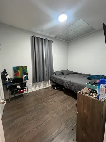 a view of kitchen with refrigerator and white cabinets