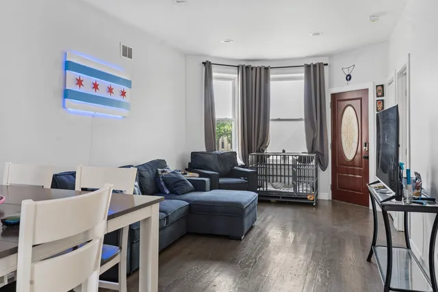 a kitchen with stainless steel appliances granite countertop a stove a refrigerator a sink dishwasher and white cabinets with wooden floor