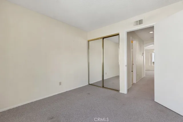 an empty room with windows and closet