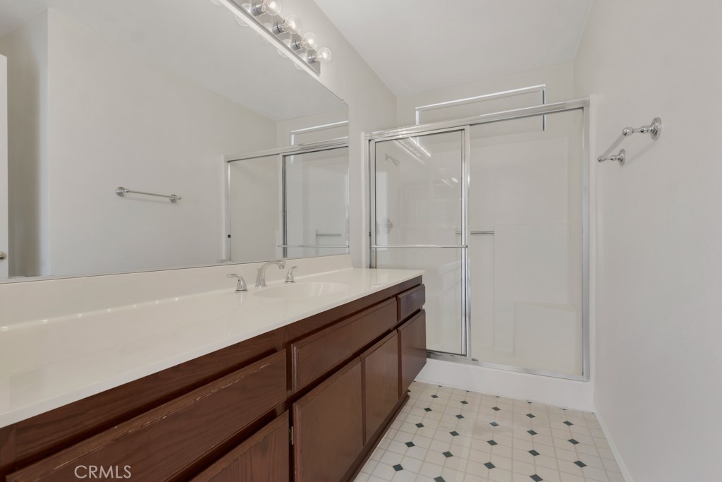 1440 Fox Run Corona, CA 92882 - Photo 18 of 23 a bathroom with a sink a mirror and a shower