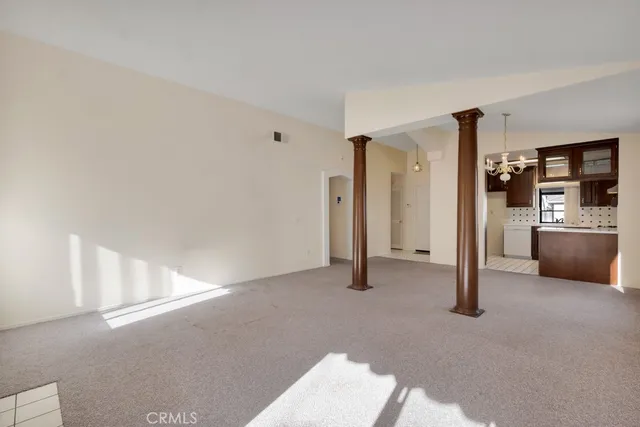 a view of a livingroom with a kitchen and a refrigerator