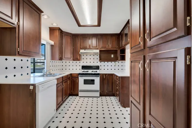 a kitchen with granite countertop a sink a counter top space and cabinets