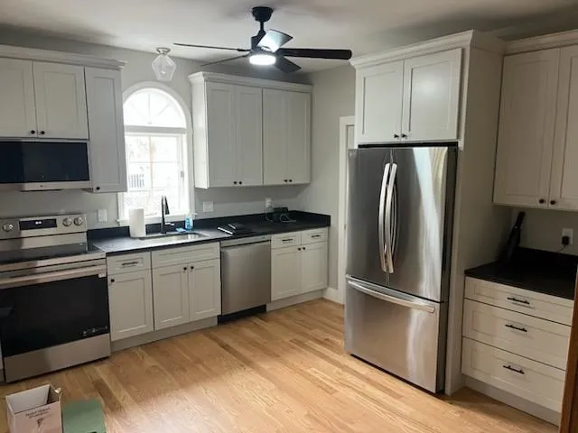 a kitchen with a refrigerator a sink and a stove top oven