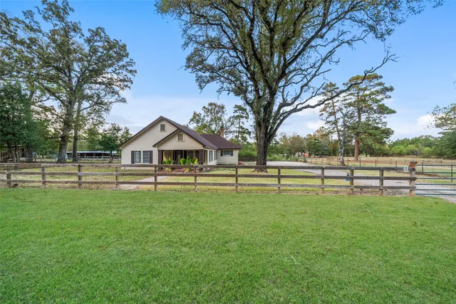 a front view of a house with a garden and trees