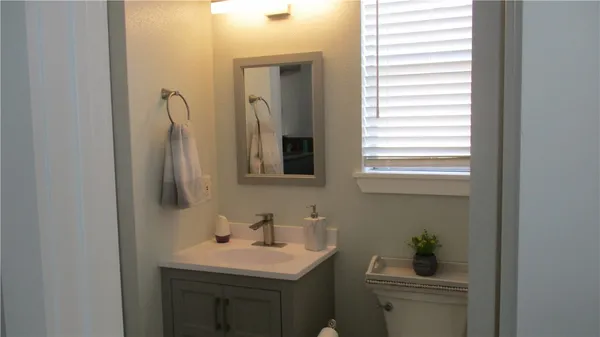 a bathroom with a sink toilet and mirror