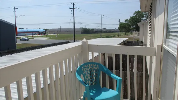a view of a balcony with yard