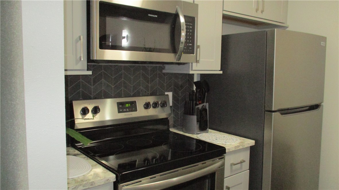 6702 Everhart Road, Unit H109 Corpus Christi, TX 78413 - Photo 3 of 18 a kitchen with a stove and a microwave