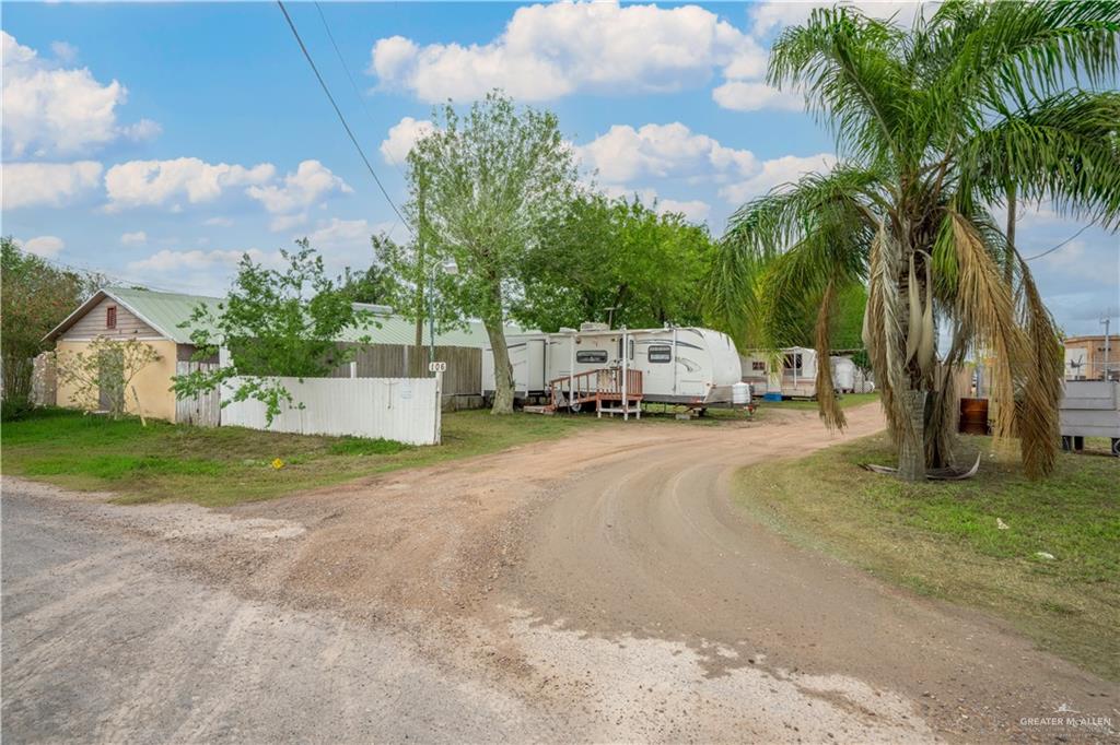 106 South Arroyo Boulevard Rio Hondo, TX 78583 - Photo 9 of 18 a white house with a yard and a car park in front of it